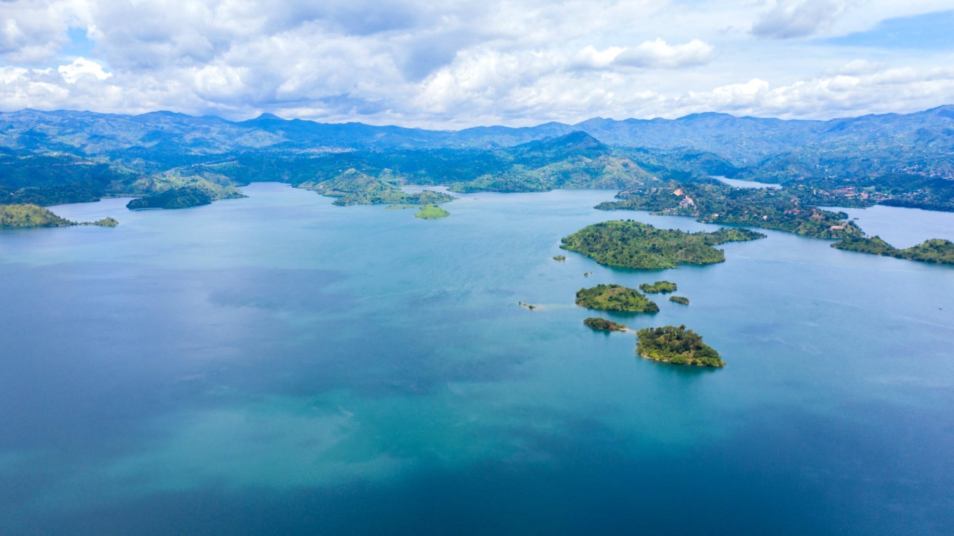 Calm waters of Lake Kivu at golden hour with distant hills